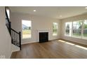 Bright living room with a fireplace, staircase, and large windows, showcasing a welcoming space at 5052 Carmine St, Brownsburg, IN 46112