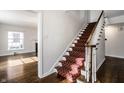 Elegant staircase featuring wood banister and carpeted steps at 5130 N Washington Blvd, Indianapolis, IN 46205