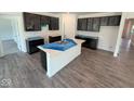 Modern kitchen with an island, dark cabinets, stainless steel sink and wood flooring at 5924 Trichel Dr, Greenwood, IN 46143