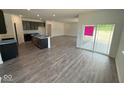 Spacious open-concept living area with dark wood floors, recessed lighting and glass sliding doors to patio at 5924 Trichel Dr, Greenwood, IN 46143