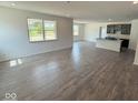 Bright and spacious living room features wood floors with a view of the modern kitchen at 5924 Trichel Dr, Greenwood, IN 46143