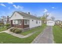 Traditional home with a spacious yard, long driveway and detached garage at 620 S Irvington Ave, Indianapolis, IN 46219
