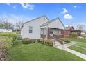 Quaint home with a covered porch and nicely landscaped front yard at 620 S Irvington Ave, Indianapolis, IN 46219
