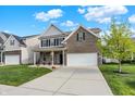 Lovely brick home with a spacious driveway and a neatly landscaped front yard on a sunny day at 6650 W Black Tail Way, McCordsville, IN 46055