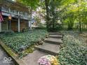 Beautifully landscaped front yard with stone steps, lighting, and lush greenery at 7037 Indian Lake W Blvd, Indianapolis, IN 46236