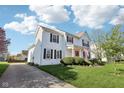 Beautiful home featuring a manicured lawn and a charming front porch with an American flag at 715 Stockbridge Dr, Westfield, IN 46074