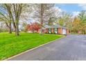 Brick home with a large front lawn and a paved driveway leading to an attached garage at 7756 N Audubon Rd, Indianapolis, IN 46250