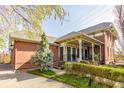 Brick home with a welcoming covered front porch, surrounded by greenery and mature trees at 902 N College Ave, Indianapolis, IN 46202