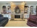 Cozy living room with a stone fireplace, built-in bookshelves, and ample natural light, creating a relaxing atmosphere at 107 Knoll Ct # F, Noblesville, IN 46062