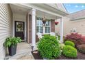 Inviting front porch with seating, decorative hanging plants, and attractive front door at 12821 Gloria Dr, Fishers, IN 46037