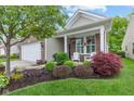 Landscaped front yard with lush greenery and flowering bushes, leading to a charming home at 12821 Gloria Dr, Fishers, IN 46037