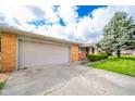 Spacious two-car garage and driveway leading to a brick home with mature landscaping at 1507 Lynnwood Dr, Anderson, IN 46012