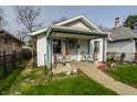 Charming single-Gathering home with a cozy front porch, landscaped with flowers, and a well-maintained lawn at 1510 Asbury St, Indianapolis, IN 46203