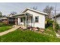 Charming single-Gathering home with a cozy front porch, landscaped with flowers, and a well-maintained lawn at 1510 Asbury St, Indianapolis, IN 46203
