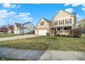 Landscaped front lawn leading to a beige two-story home with a two-car garage at 16271 Ambia Cir, Westfield, IN 46074