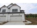 Modern farmhouse with white siding, black roof, and concrete driveway in front of a two-car garage door at 17466 Ebling Trl, Westfield, IN 46062