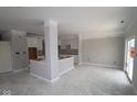 An open concept kitchen features white cabinets and a center island at 17466 Ebling Trl, Westfield, IN 46062