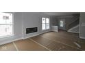 Bright living room features large windows, a modern fireplace, staircase, and is ready for personalized finishing touches at 17466 Ebling Trl, Westfield, IN 46062