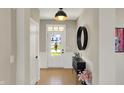 Bright foyer with hardwood floors, modern light fixture, and neutral wall color at 180 Oakhurst Way, Westfield, IN 46074