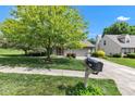 Charming home features a well-manicured lawn, mature tree, and inviting curb appeal on a sunny day at 3611 Owster Ln, Indianapolis, IN 46237
