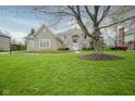 Beautiful brick home with a lush green lawn and mature tree in a suburban setting at 3837 Penzance Pl, Carmel, IN 46032