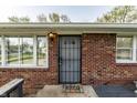 A welcoming front entrance features a brick facade, a security door, and a 'Home' welcome mat at 3909 Aloda St, Indianapolis, IN 46203