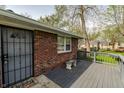This home offers a cozy front porch, a brick facade, a security door, and a concrete bench at 3909 Aloda St, Indianapolis, IN 46203