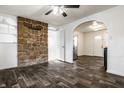 Inviting living room featuring a stone accent wall, arched doorways, and modern ceiling fan at 3909 Aloda St, Indianapolis, IN 46203