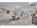 Light-filled dining area with chandelier, adjacent to kitchen with marble island and an open-concept design at 401 Sanders St, Indianapolis, IN 46225