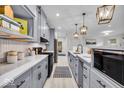 Well-lit kitchen featuring gray cabinetry, stainless appliances, quartz countertops, and decorative pendant lighting at 401 Sanders St, Indianapolis, IN 46225