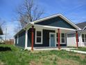 Charming home featuring a blue front door, red pillars, and well-maintained lawn at 4230 Kingsley Dr, Indianapolis, IN 46205