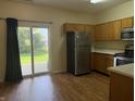 Bright kitchen with stainless steel appliances, wood cabinets, and sliding glass doors leading to the backyard at 4932 Tuscany Ln, Indianapolis, IN 46254
