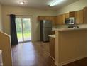 Bright kitchen with stainless steel appliances, wood cabinets, and sliding glass doors leading to the backyard at 4932 Tuscany Ln, Indianapolis, IN 46254