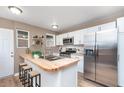Modern kitchen featuring stainless steel appliances, a butcher block island, and white cabinets at 5074 E Walnut St, Indianapolis, IN 46201