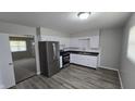 Modern kitchen featuring stainless steel appliances, white cabinets, and wood-look flooring at 5636 W Henry St, Indianapolis, IN 46241