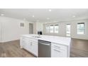 Open-concept kitchen island with stainless steel dishwasher flows into the living room at 5661 Stetson Dr, Whitestown, IN 46052