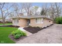 Charming stone home with driveway, manicured lawn, and landscaping at 5715 N Meridian St, Indianapolis, IN 46208