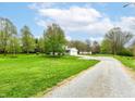 Property featuring a long gravel driveway leading to a two-car garage at 6113 N 250 E, Greenfield, IN 46140