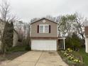 Two-story home featuring a two-car garage, neutral siding, and landscaping at 6534 Redland Way, Indianapolis, IN 46217
