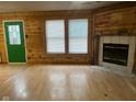 Living room featuring wood walls, laminate flooring, and a fireplace at 6534 Redland Way, Indianapolis, IN 46217