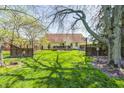 Large backyard with a deck, privacy fence, and mature trees, perfect for outdoor enjoyment at 7114 Hickory Rd, Indianapolis, IN 46259