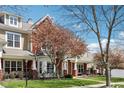 Charming townhome exterior with blooming tree, porch swing, and well-manicured lawn at 720 Bucksport Ln, Westfield, IN 46074
