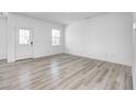 Bright living room featuring light wood floors, a large window, and neutral walls, creating a modern space at 7265 Governors Row, Avon, IN 46123