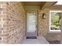Close-up of a brick front porch with storm door, brick detail, and front door light fixture at 8218 San Carlos Ct, Indianapolis, IN 46256