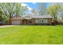 A well-maintained ranch-style house features a manicured lawn, brick facade, and attached garage at 8218 San Carlos Ct, Indianapolis, IN 46256