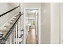 Bright hallway featuring hardwood floors and a staircase with black and white accents at 8639 Lancaster Rd, Indianapolis, IN 46260
