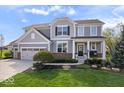 Charming two-story home with a manicured lawn, a three-car garage, and a welcoming front porch with white columns at 957 Commander Ct, Westfield, IN 46074
