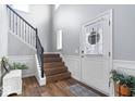 Bright foyer featuring hardwood floors, a staircase with decorative trim, and a white front door with sidelight at 957 Commander Ct, Westfield, IN 46074