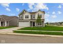 Charming two-story home featuring a well-manicured lawn and a two-car garage on a sunny day at 10138 Redwood Peak Ln, Indianapolis, IN 46259
