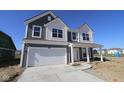 Two-story home with a white two-car garage, covered porch, gray siding and manicured lawn at 10138 Redwood Peak Ln, Indianapolis, IN 46259